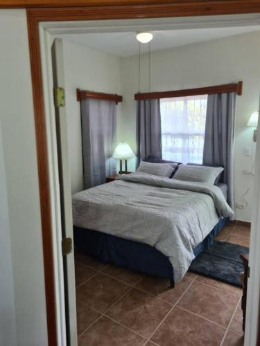 圣伊格纳西奥Casa Maya的一间卧室设有一张大床和一个窗户。
