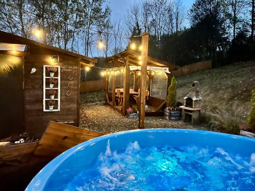 索利纳Bieszczadzka Osada Saunowisko-dom z jacuzzi sauną na wyłączność的院子里一个装满蓝色水的大浴缸