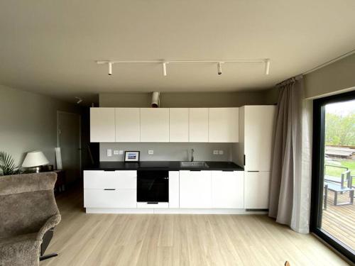 特罗姆瑟Hjemmekoselig leilighet med nydelig utsikt的一间厨房,内设白色橱柜和沙发