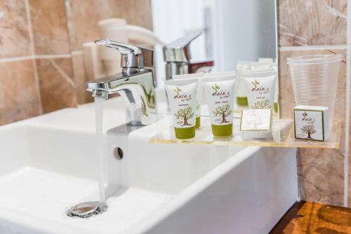 拉多斯Belmare Hotel-Adults Οnly的浴室水槽设有水龙头和植物架子