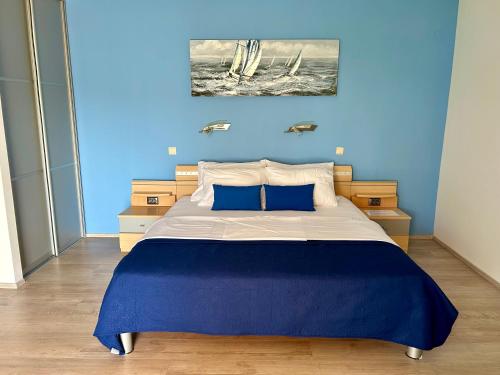 木洛希尼Apartment Stella的一间卧室配有一张带蓝色墙壁的大床