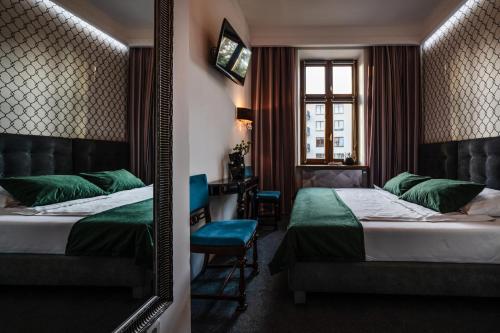 克拉科夫Aparthotel Maargick的酒店客房,设有两张床和镜子