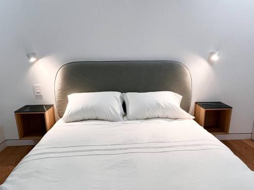 布鲁克林New Beautiful Modern One Bedroom Apt in Brooklyn at Rem-Casa的一张带两个床头柜和两个白色枕头的床
