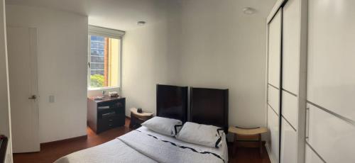 波哥大Acogedor apartamento en zona corporativa Ciudad Salitre的一间卧室设有一张床和一个窗口