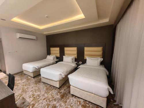 麦地那فندق دان البلاتيني的一间酒店客房,房间内设有三张床