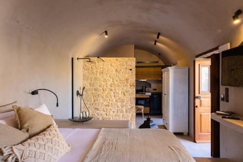 哈尔基岛EliteDIMension Chalki的一间卧室配有一张床,厨房配有冰箱