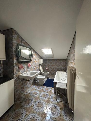 布伦托尼科CA' EDDA APPARTAMENTO GIULIA的一间带两个盥洗盆和卫生间的浴室以及一台电视。