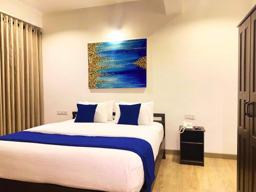 努沃勒埃利耶Queens Mount Glen Heights的一间卧室配有一张带蓝白色枕头的大床