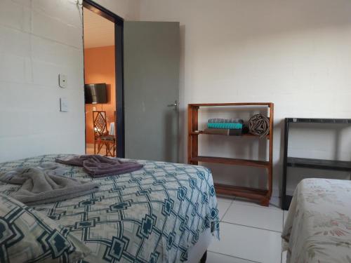 阿奎拉兹Pousada Alecrim的一间卧室配有一张床铺,床上有毯子
