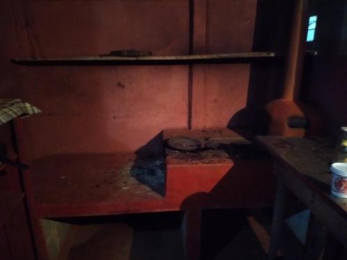 圣罗克迪米纳斯CAMPING SÃO BENEDITO的一个带桌子和架子的房间内的炉灶
