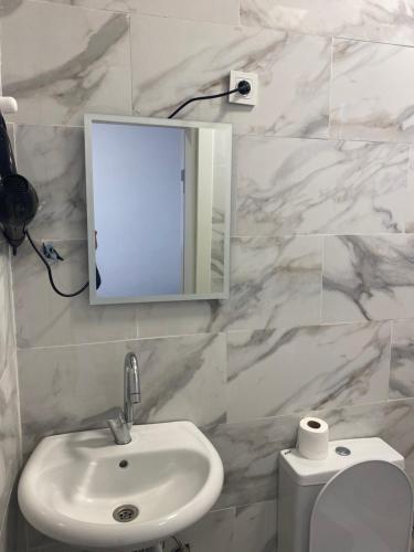 伊斯坦布尔yenikapı hotel的一间带水槽、镜子和卫生间的浴室
