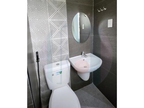 萨马尔RiCres Hometel Double Bed R124的一间带卫生间、水槽和镜子的浴室