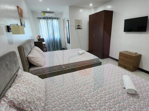 萨马尔RiCres Hometel Double Bed R124的酒店客房,设有两张床和一张沙发