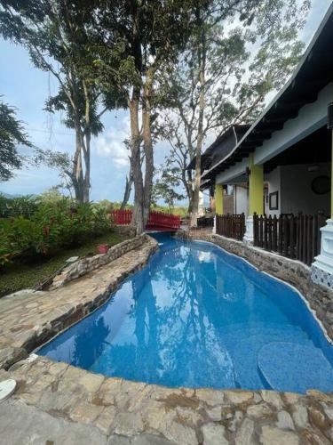 OstumánAlpinas Montecarlo的一座房子旁的院子内的蓝色游泳池