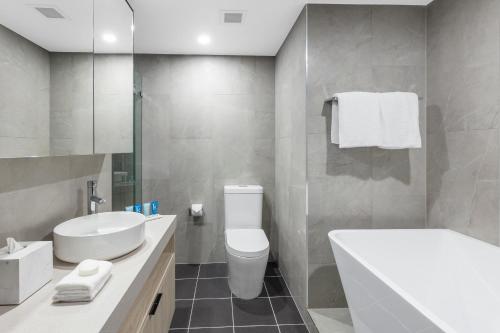悉尼邦迪交界处美利通公寓式酒店的浴室配有白色卫生间和盥洗盆。