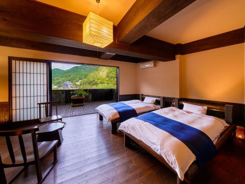 真庭市Yukai Resort Terunoyu的一间卧室设有两张床和大窗户