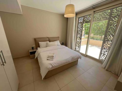 赫尔格达One Bedroom - Mangroovy El Gouna的一间卧室设有一张床和一个大窗户
