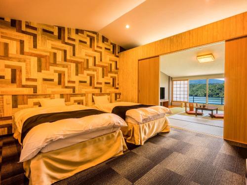 恵那市Yukai Resort Premium Enakyo Kokusai Hotel的一间卧室设有两张床和木墙