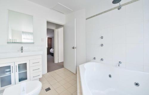 尼尔森湾尼尔森湾微风度假村的白色的浴室设有浴缸和卫生间。