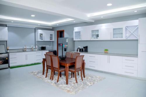 坎帕拉Brand New Condo Apartment的厨房配有桌椅和冰箱。