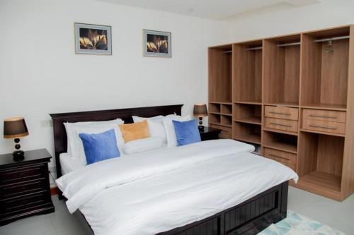 坎帕拉Brand New Condo Apartment的一间卧室配有一张大床和木制橱柜。