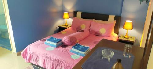 波德申可可湾放松公寓的一间卧室配有一张粉红色的床和两盏灯
