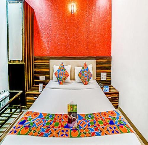 孟买FabHotel The Adore Palace的一间卧室配有一张大床和彩色床罩