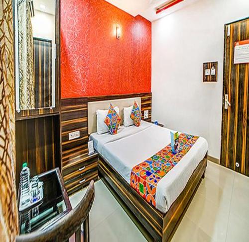 孟买FabHotel The Adore Palace的一间卧室配有一张床和一把椅子