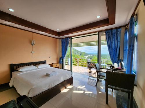 素叻Baan Khao Noi Resort的一间卧室配有一张床铺和一张桌子,并设有一个阳台
