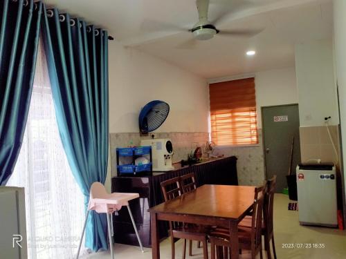 Tanjung KarangSri Manik Guest House Tanjung Karang的厨房以及带桌子和蓝色窗帘的用餐室。