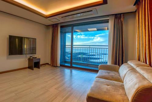 济州市O2Heal resort的带沙发和大窗户的客厅