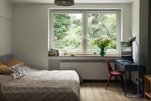 杜伊斯堡Central apartment with Terrace的一间卧室配有一张床、一张书桌和一个窗户。