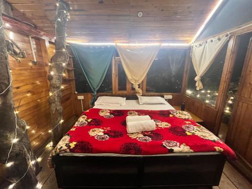 吉布Nebula Nook TreeHouse的一间卧室配有一张红色棉被的床