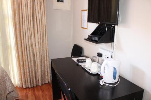 马塞卢Boikhutsong Bed & Breakfast的客房设有一张书桌和一台咖啡机