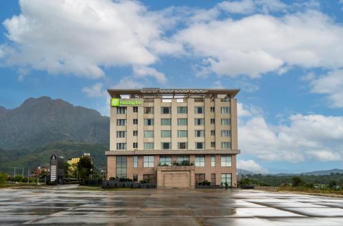 格德拉Holiday Inn Katra Vaishno Devi, an IHG Hotel的酒店大楼前面设有停车场