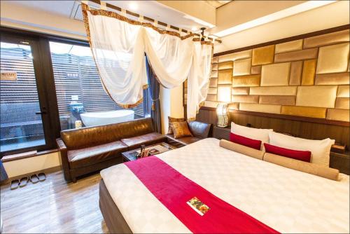 东京HOTEL PetitBali Higashi-Shinjuku的一间卧室配有一张床、一张沙发和一个窗口