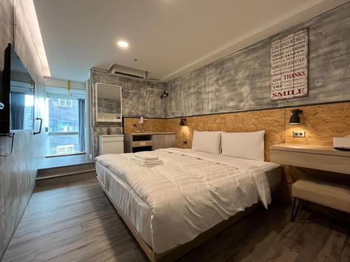 台南台南府城窝旅的卧室配有一张白色大床和一张书桌