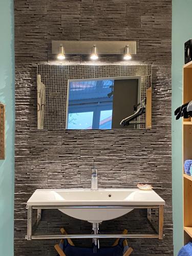 布格奈斯Studio dans maison avec parking的一间带水槽和镜子的浴室