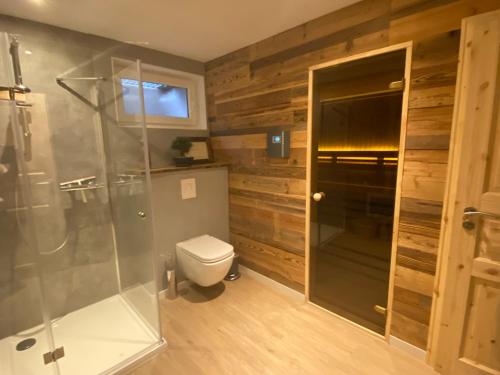 圣安德里斯伯格Lina's Ferienwohnungen - zwei moderne FeWos mit Sauna im Haus und fantastischem Ausblick的一间带卫生间和玻璃淋浴间的浴室