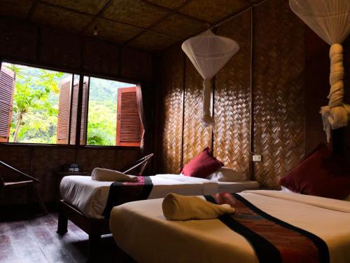 北宾湄公河河畔酒店的一间卧室设有两张床和两个窗户。