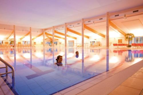 奥斯赛拜-屈隆斯博恩莫拉达斯特昂德奥斯摆德库伦斯伯恩酒店的两个孩子在大型游泳池游泳