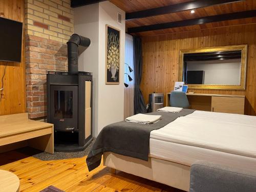 ŠiaudinėDuarto house, Sauna and Hot Tub的一间卧室配有一张床和一个燃木炉子