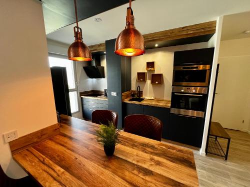 瑟堡Appartement de standing avec parking privé的厨房以及带木桌的用餐室。