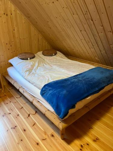 CieciorkaDomek całoroczny HAWAJE nad jeziorem Kazub的木地板客房的一张床位