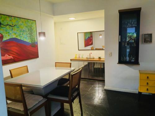 里约热内卢Plaza Elysees 202的一间带桌椅和绘画的用餐室