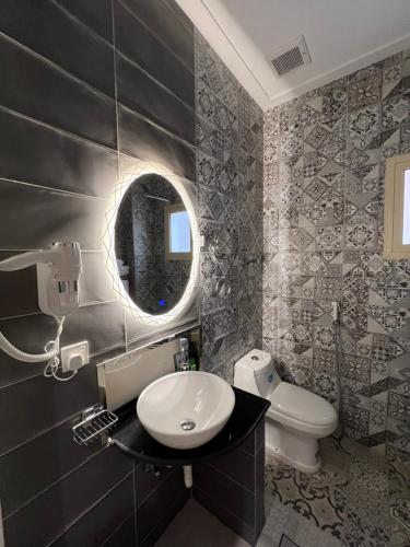 麦地那فندق الليالي الحالمة的一间带水槽、卫生间和镜子的浴室