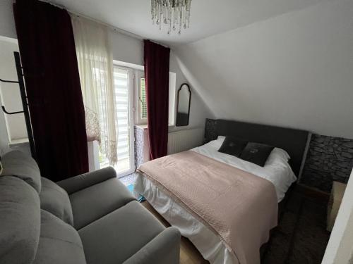 维也纳lovely house for relaxing trips的一间卧室配有一张床和一张沙发,毗邻窗户