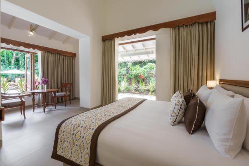 果阿旧城ama Stays & Trails Palmeira De Socorro , Goa的一间带大床的卧室和一间餐厅