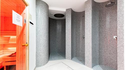 斯克拉斯卡波伦巴Apartament Familijny的带淋浴的浴室和灰色的瓷砖墙壁