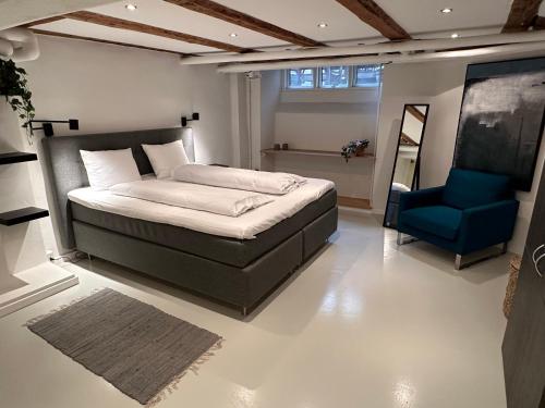 哥本哈根PSG 23 - Short Stay Apartments by Living Suites的一间卧室配有一张床和一张蓝色椅子